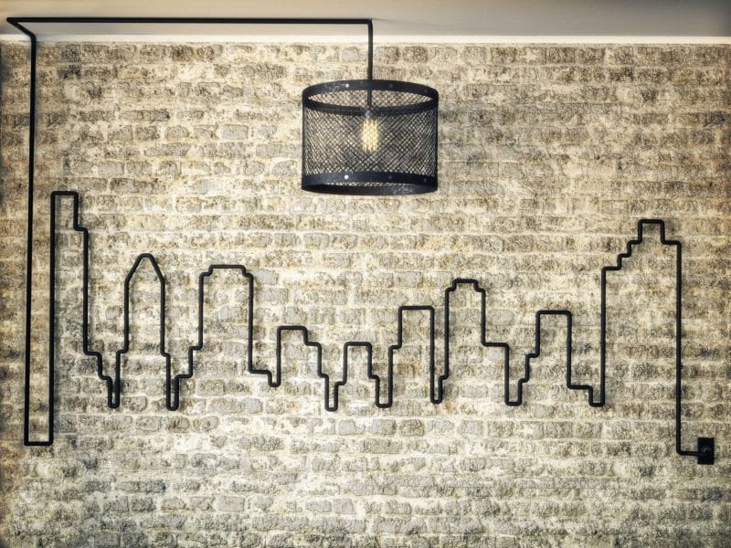 Kabel an einer Wand zu den Umrissen einer Großstadt-Skyline geformt.