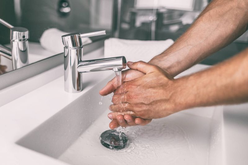 Mann beim Händewaschen im Waschbecken