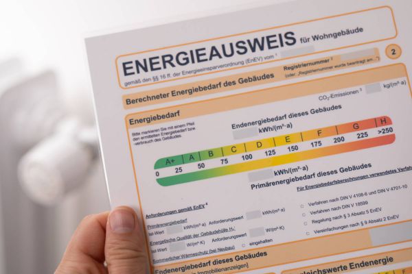 Mann hält Energieausweis in der Hand. 