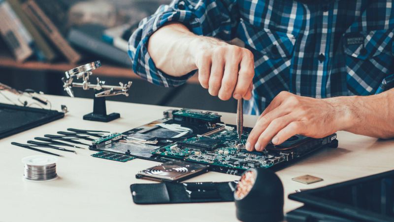 Mann repariert Einzelteile eines Computers