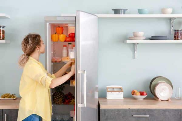 Frau öffnet Kühlschrank