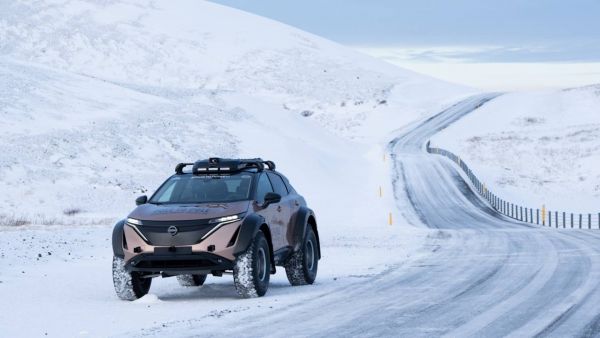 Nissan Ariya fährt auf einer Straße im Schnee