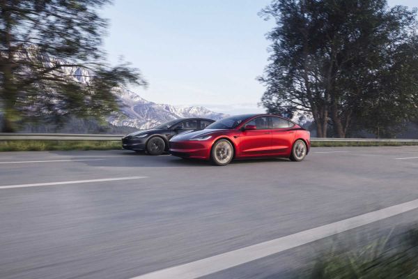 Zwei Tesla Model 3 Limousinen auf der Straße, während der Fahrt.
