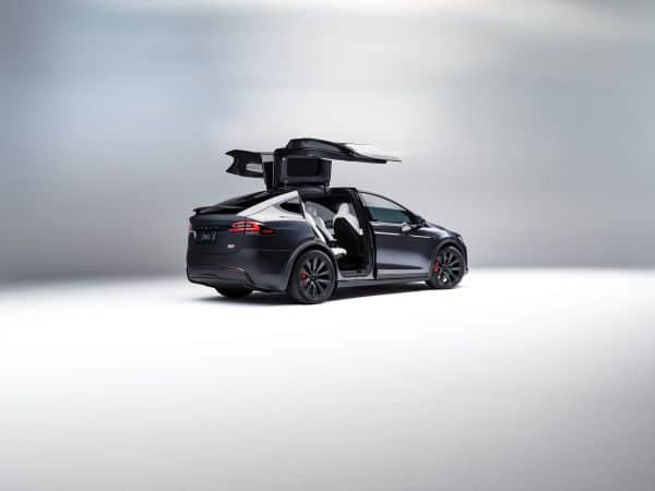 Schwarzer Tesla Model x mit geöffneten Flügeltüren.