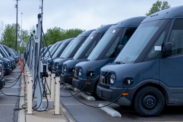 Amazons Elektro-Transporter Flotte lädt an Ladesäulen.