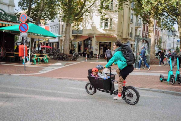 Mann cruist mit dem E-Muli durch die Stadt